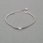 Recycled silver snake chain bracelet with round disc charm on fabric