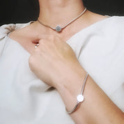 Model wearing silver snake choker draped over wrist
