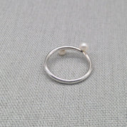 Angled view of recycled silver wrap ring with pearl detail
