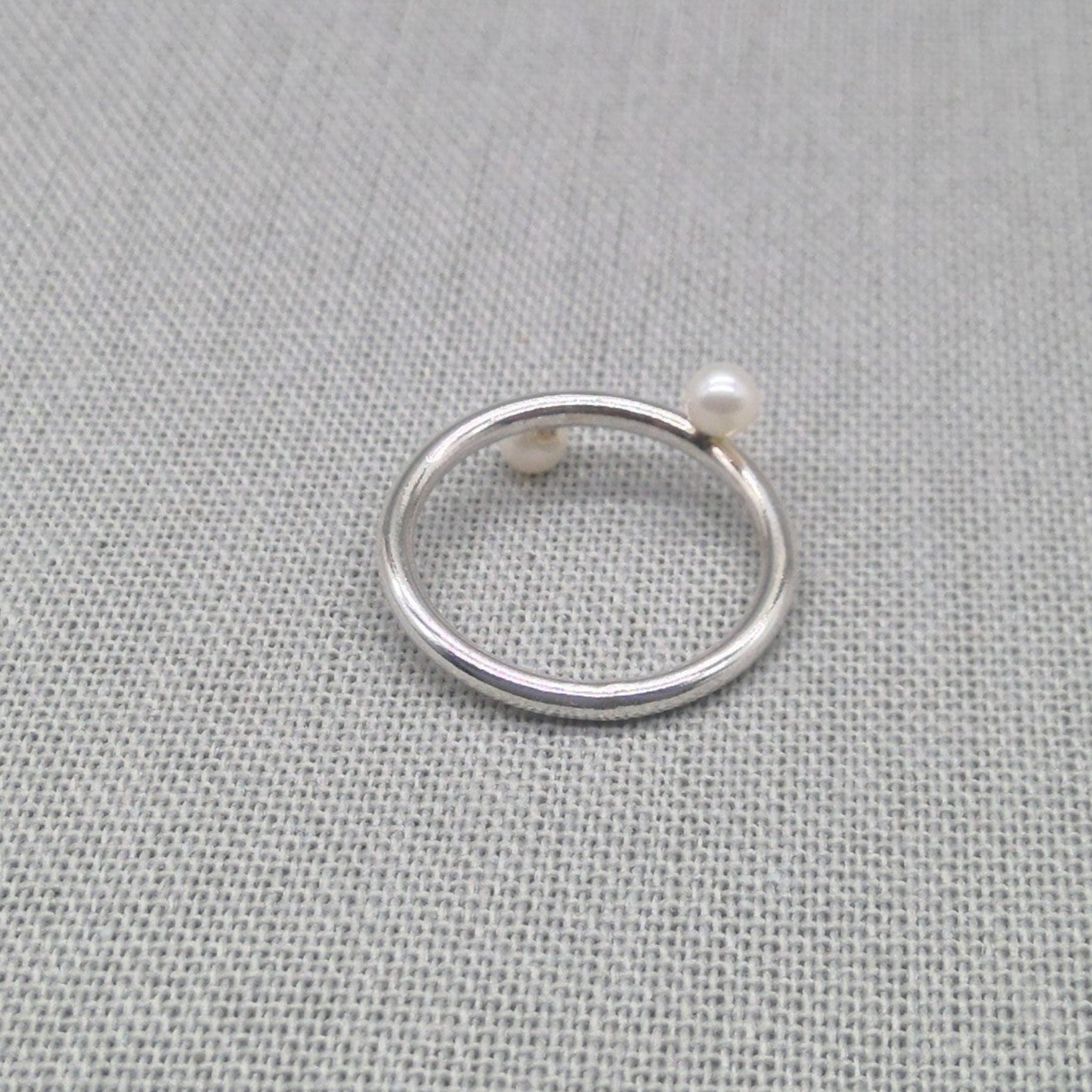 Angled view of recycled silver wrap ring with pearl detail
