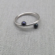 Angled view of silver wrap ring with black bead ends