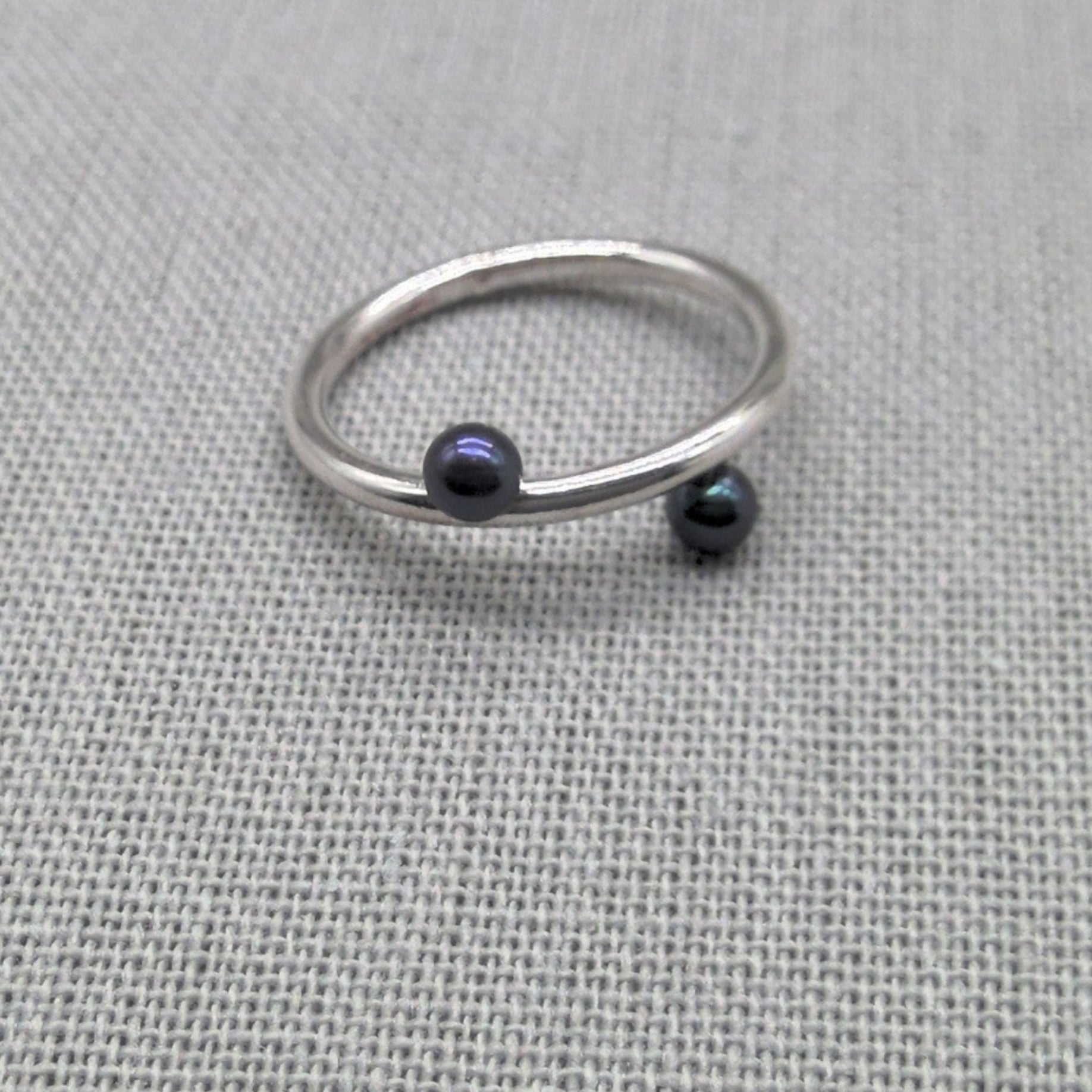 Angled view of silver wrap ring with black bead ends