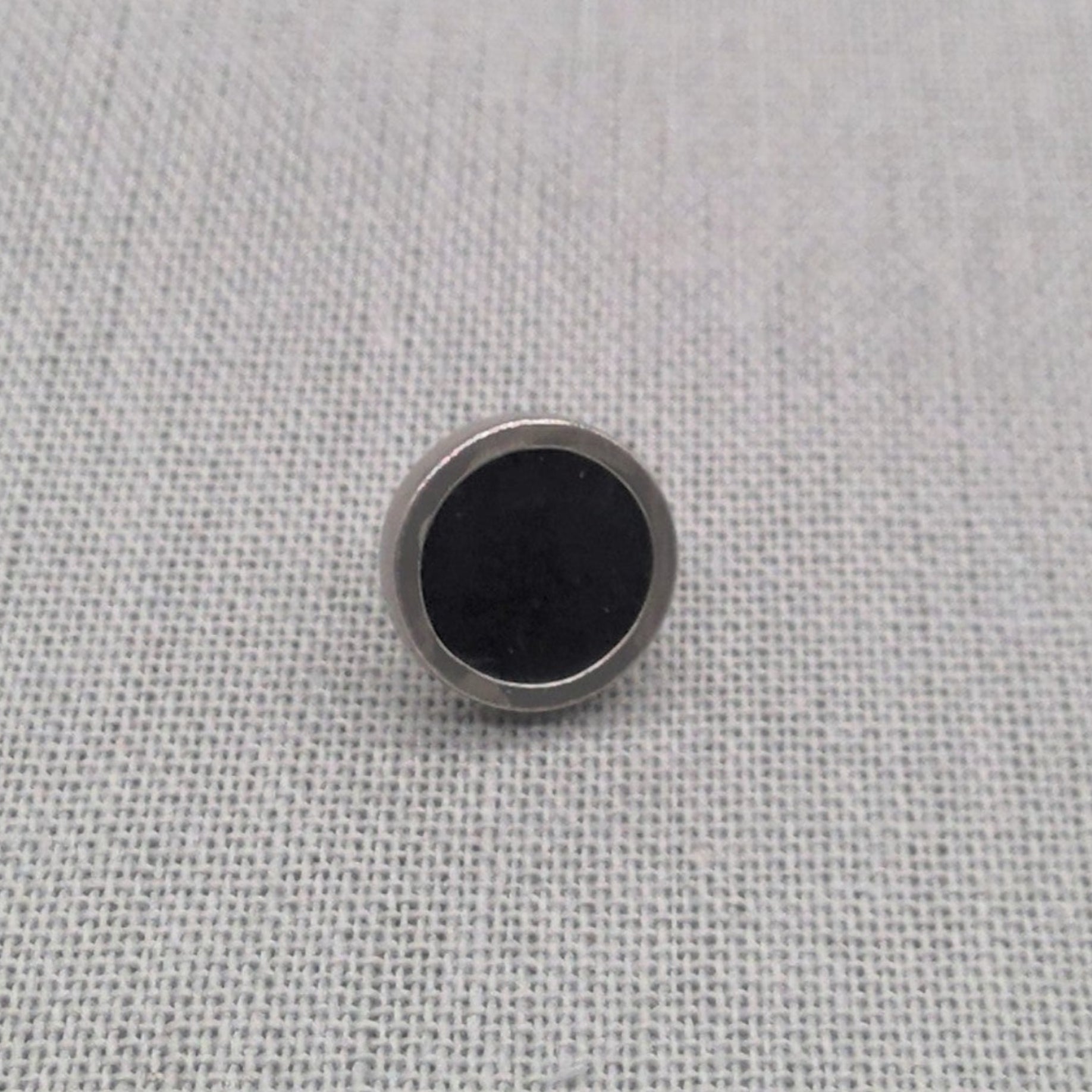 Close-up of black resin recycled silver stud earring