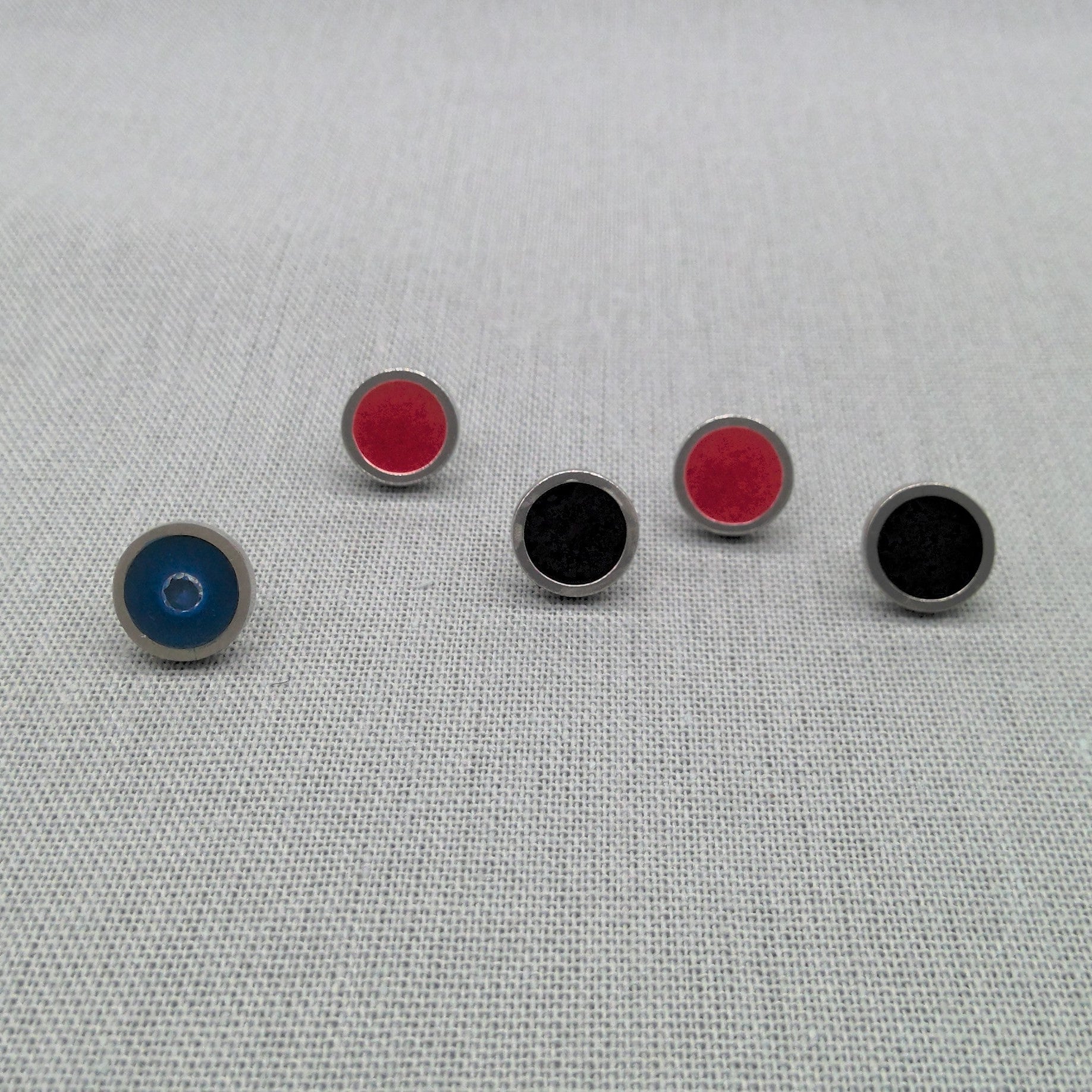 Range of single resin recycled silver studs in blue, black, and red