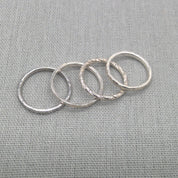 Close view of textured and smooth silver stacking ring bands