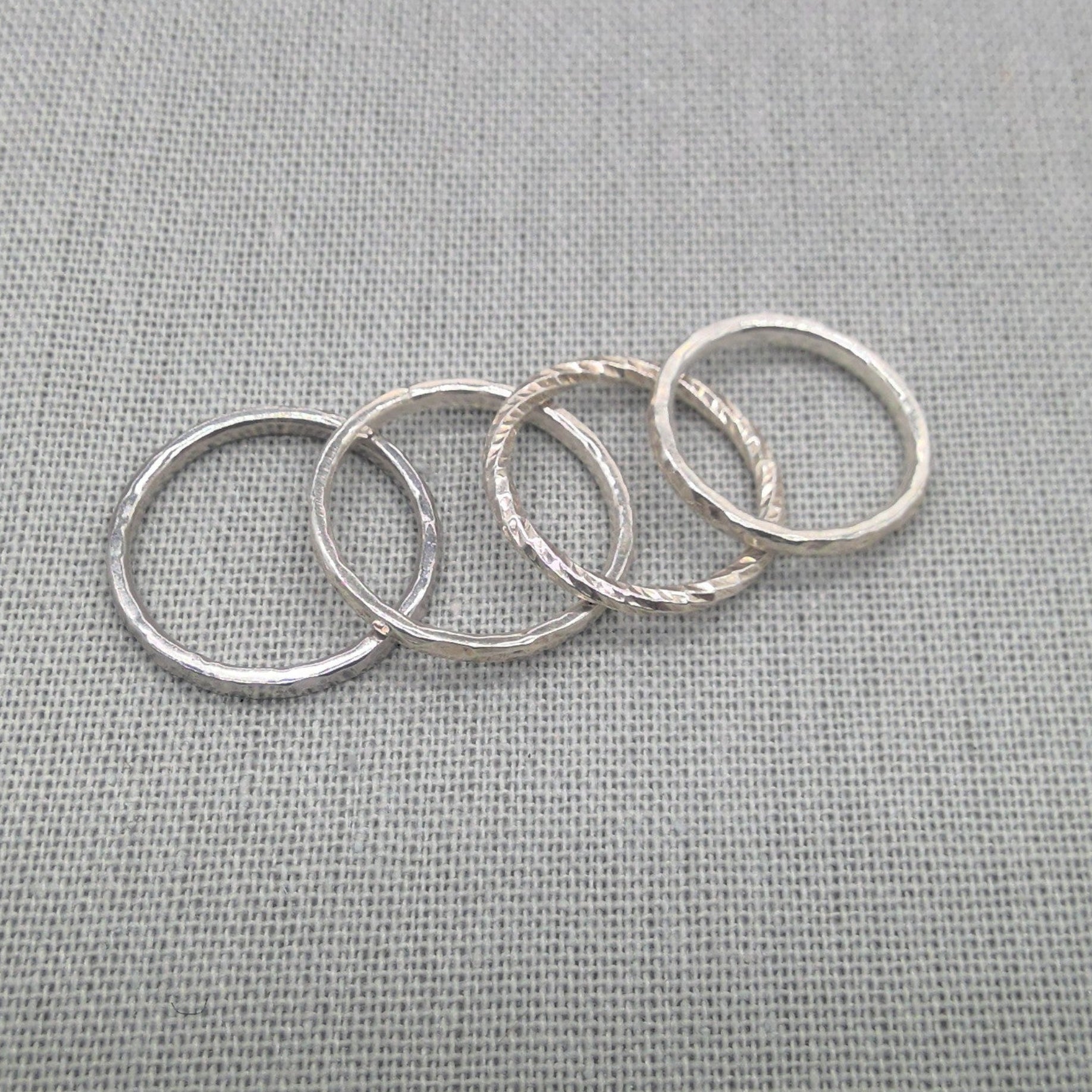 Close view of textured and smooth silver stacking ring bands