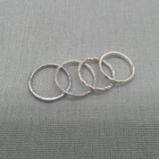 Textured recycled silver stacking rings arranged in a row