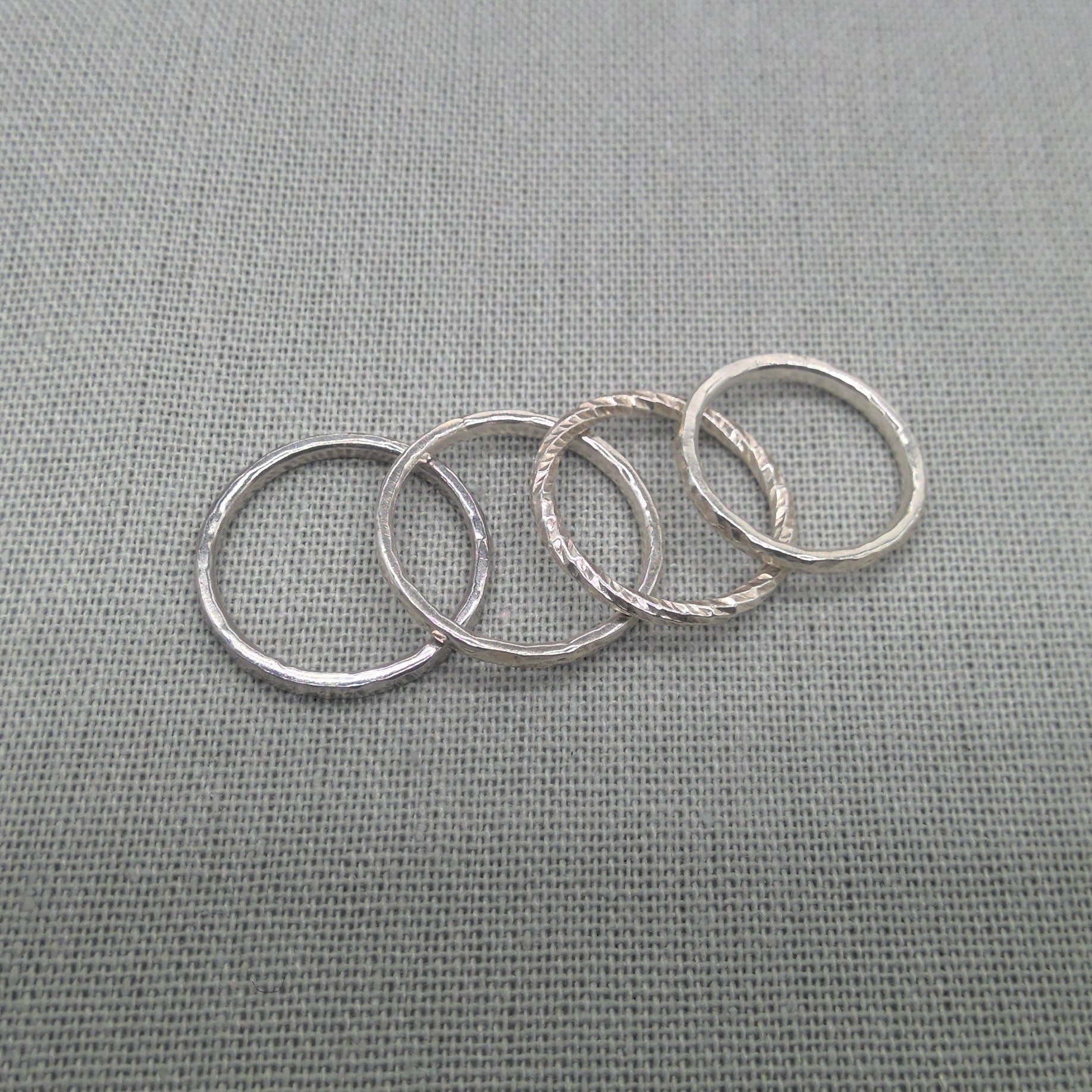 Textured recycled silver stacking rings arranged in a row
