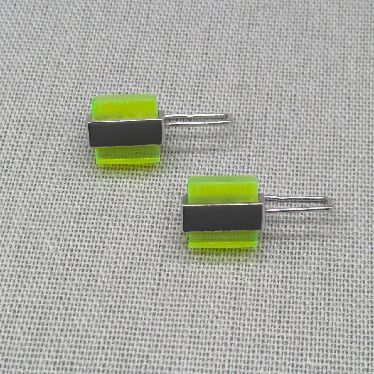 Angled view of two-tone neon Perspex silver stud earrings